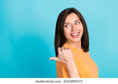 Close up photo of cheerful pretty cute lady wear trendy orange clothes arm direct empty space look news isolated on blue color background - Shutterstock ID 2262803571
