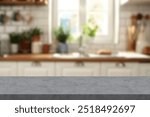 Close up photo of contemporary kitchen island with stone marble table top with kitchen blurry loose focal background