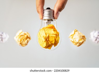Close up photo of crumbled colorful paper and light bulb in the same frame as a symbol of persistance, perseverance and hardwork. Concept of creative idea , brainstorm and innovative thinking. - Shutterstock ID 2204100829