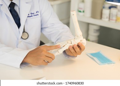 Close Up Photo Of Doctor In White Gown Sitting At The Clinic. Doctor Explain The Patient With Foot Model. Bunion Pain From Hallux Valgus And Plan To Do Surgery.