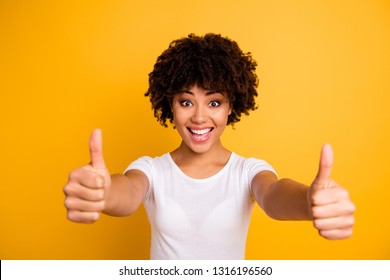 Close up photo easy-going beautiful amazing she her dark skin lady arms hands finger thumb up approve quality advising buy buyer wearing casual white t-shirt isolated yellow bright vivid background