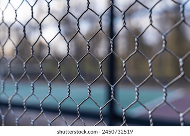 Close up photo of an elevated Platform Tennis, Paddle Ball courts chicken wire fence. - Powered by Shutterstock