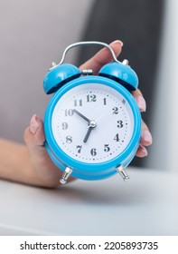 Close up photo of female hand holding alarm clock. Wake up and hurry up concept - Shutterstock ID 2205893735