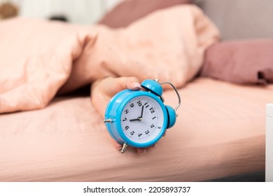 Close up photo of female hand holding alarm clock. Wake up and hurry up concept - Shutterstock ID 2205893737