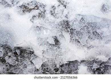 Close Up Photo Of Frozen Cracked Icy Ground Surface Texture Background.