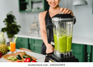 Close up photo of a girl making detox cocktail using blender in the kitchen. Smoothie and super food for healthy diet and eating habits. Vitamins and fiber source - Powered by Shutterstock