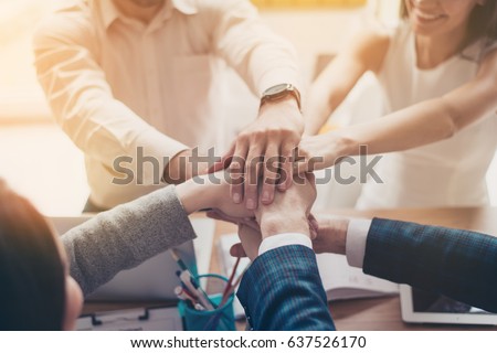 Close up photo of hands on top of each other of successful business partners who are working in team for one goal and happy to share victory with each other