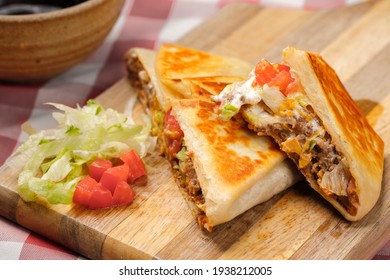 A Close Up Photo Of A Homemade Crunch Wrap Taco On A Cutting Board.