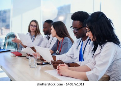 Close Up Photo Of International Team Of Professional Doctors Having A Meeting In Conference Room At The Modern Hospital. Health Care And Medical Developmant Concept.