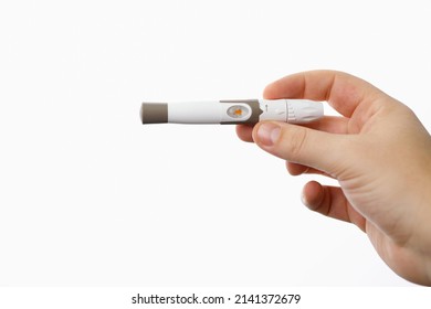 Close up photo of a lancet for checking blood sugar level by glucose meter man holding in his hand on white background.