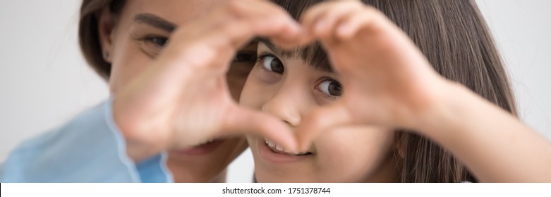 Close up photo little daughter and mother join fingers forming heart shape as concept sign of charity and donation, adoption kid and childcare, family bond. Horizontal banner for website header design - Shutterstock ID 1751378744