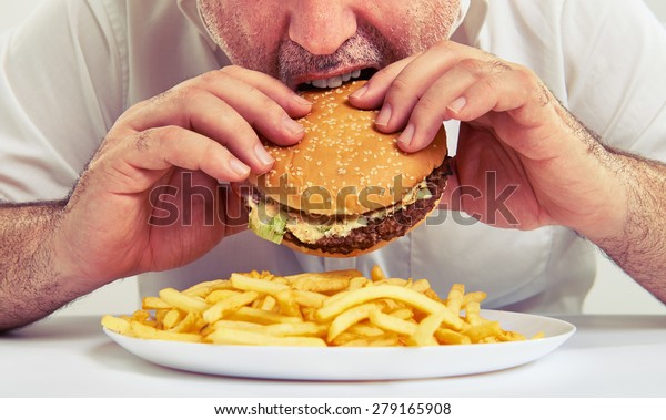 close up\
photo of man eating burger and french\
fries