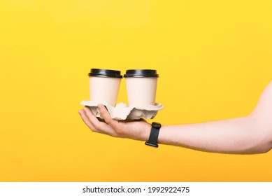 Close Up Photo Of Man Hand Holding Two Paper Cups Of Coffee To Go.