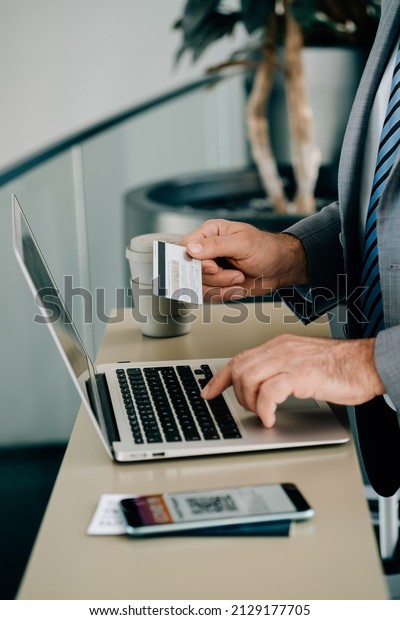 Close Up Photo of Man Hands Using Laptop
Computer and Credit Card for Making Online Reservation or to Pay
Taxes or Fee while Waiting at the
Airport