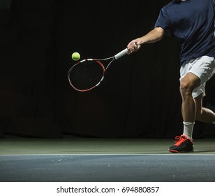 Close up photo of a man swinging a tennis racquet during a tennis match. - Powered by Shutterstock