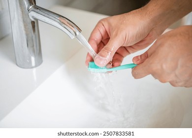 Close up photo of man washing toothbrush after using	 - Powered by Shutterstock