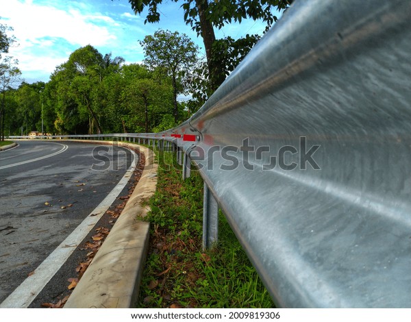 a close up photo of a metal road divider on an empty\
asphalt road