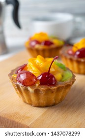 Close Up Photo Of Mini Fruit Tart With Orange Cherry And Kiwi. Dessert With Black Coffee