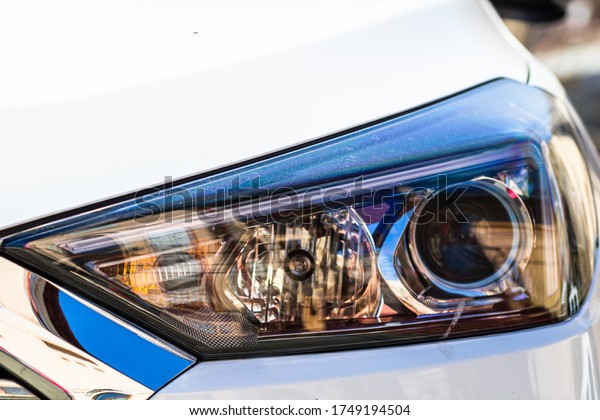 Close up photo of modern car, detail of\
headlight. Headlight car Projector LED of a modern luxury\
technology and auto\
detail.