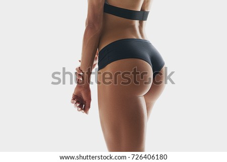 Close up photo of muscular woman legs isolated on white background. Woman bodybuilder buttocks