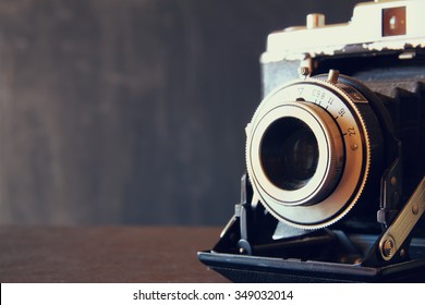 close up photo of old vintage camera lens over wooden table. selective focus 