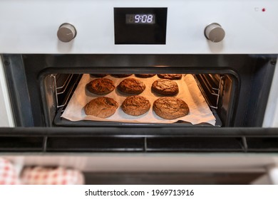 Close up photo of oven with a tray of cookies, hand opening the oven door.tif