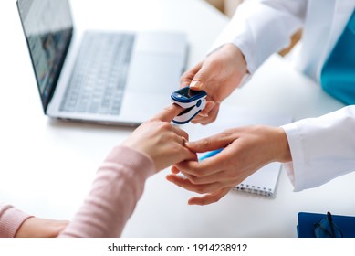 Close up photo of oxygen pressure measurement. Female hands of a doctor and patient. Doctor uses a pulse oximeter to measure the patient's pulse and oxygen level