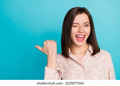 Close up photo of positive lady wear stylish blouse wink eye thumb arm direct empty space cool discount isolated on cyan color background - Shutterstock ID 2229077563