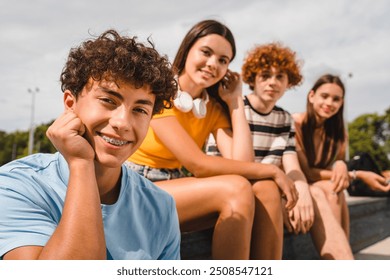 Close up photo of positive multiracial teenagers high school pupils friends classmates college students boys and girls hanging out together in urban street park sport court outside looking at camera - Powered by Shutterstock