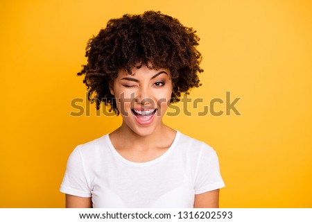 Close up photo pretty amazing she her dark skin lady cool look glad winking one eye mouth open laugh laughter wearing casual white t-shirt isolated yellow bright vibrant vivid background