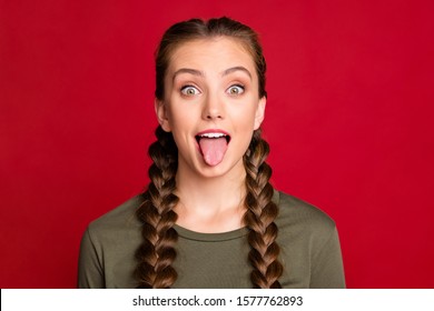 Close up photo of pretty teen model lady playing with classmate sticking tongue out mouth wear casual pullover isolated red color background