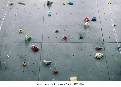 Close Up Photo Of A Rock Climbing Wall With Climbing Holds In Gym