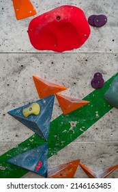 Close Up Photo Of A Rock Climbing Wall With Climbing Holds In Gym. 