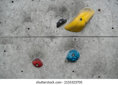 Close Up Photo Of A Rock Climbing Wall With Climbing Holds In Gym. 