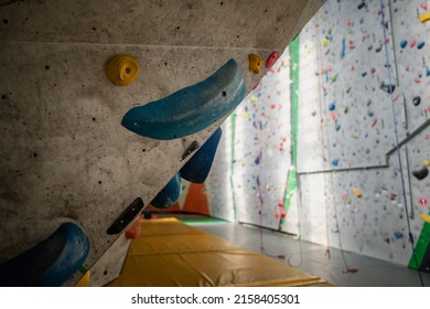 Close Up Photo Of A Rock Climbing Wall With Climbing Holds In Gym. 