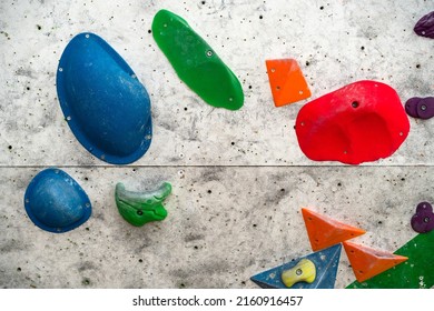 Close Up Photo Of A Rock Climbing Wall With Climbing Holds In Gym. 