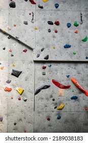 Close Up Photo Of A Rock Climbing Wall With Climbing Holds In Gym. 