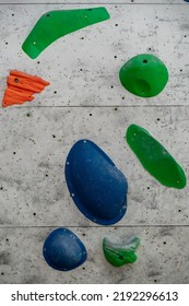 Close Up Photo Of A Rock Climbing Wall With Climbing Holds In Gym. 