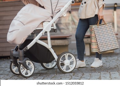 Close Up Photo, Shopping With Baby In Stroller, Woman Holding Shopping Bags.