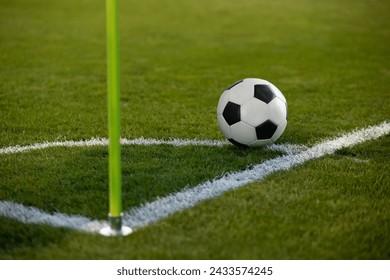 Close up photo of a soccer ball resting on the corner circle ready for a corner kick during a soccer game. Selective focus on the ball. Good generic soccer image.