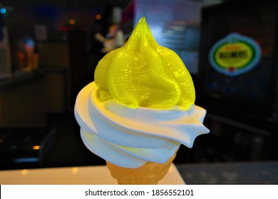 A close up photo of a soft whip ice cream with lemon sauce on top