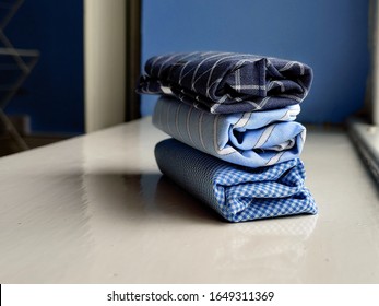 A close up photo of some beautiful blue handkerchiefs, showing their detail and texture. They are 100% cotton. Some have a striped pattern, while others have a checkered or plaid pattern.