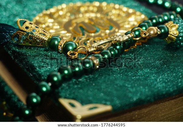 Close up Photo of Tasbih Muslim prayer beads in\
glossy Golden and green\
colour.