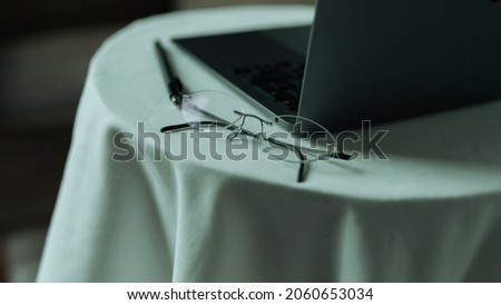 Close Up Photo of a Therapist Glasses and a Grey Laptop on a White Table 