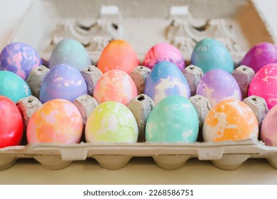 Close up photo of Tie Dye Easter eggs colored for the holiday and displayed in an egg carton - Powered by Shutterstock