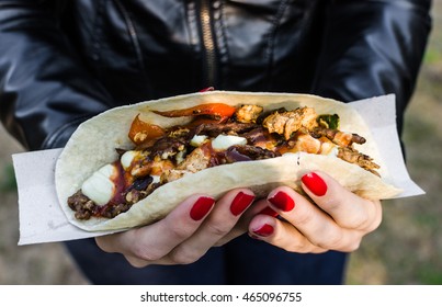 Close up photo of a traditional Mexican taco with beef filling at a street food market. Selective focus. - Powered by Shutterstock