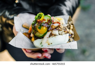 Close up photo of a traditional Vietnamese banh bao steamed bun with pork filling at a street food market. Selective focus.