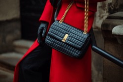 Close Up Photo Of Trendy Black Quilted Faux Leather Baguette Bag, Purse In Fashionable Winter Outfit. Woman Wearing Red Coat, Gloves, Posing In Street. Copy, Empty, Blank Space For Text
