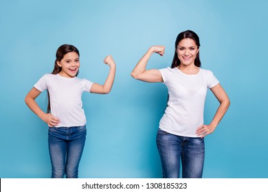 Close up photo two people brown haired mum mom small little daughter hand on biceps who run world girls wear white t-shirts isolated bright blue background