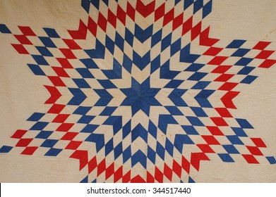 Close Up Photo Of A Vintage American Patchwork Quilt In Red, White And Blue, Lone Star Design